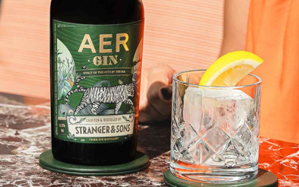 Four Seasons Hotel Mumbai and Third Eye Distillery Unveil AER Gin 8 a bottle of AER Gin next to a glass of ice and a slice of lemon