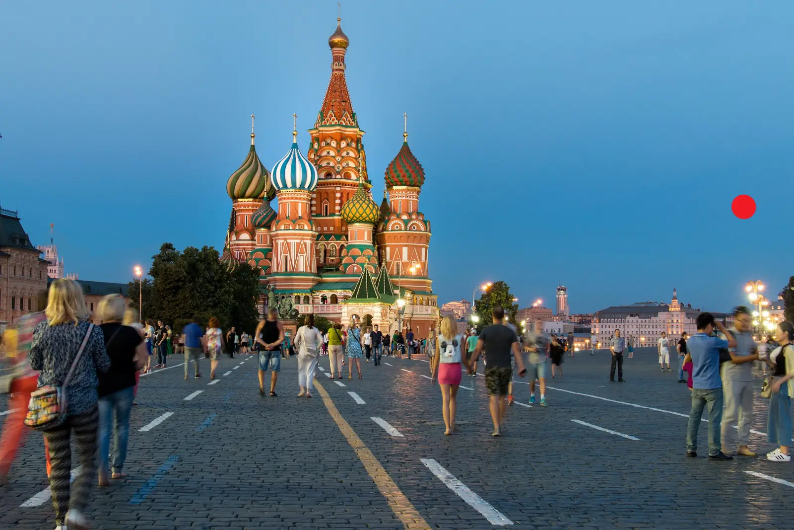 People walking on Red Square in front of Saint Basil’s Cathedral at dusk in Moscow